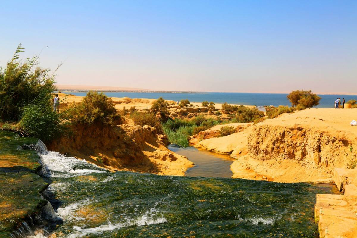 Las cascadas de Wadi El Rayan, con agua fluyendo sobre rocas calizas en un paisaje desértico de Fayoum