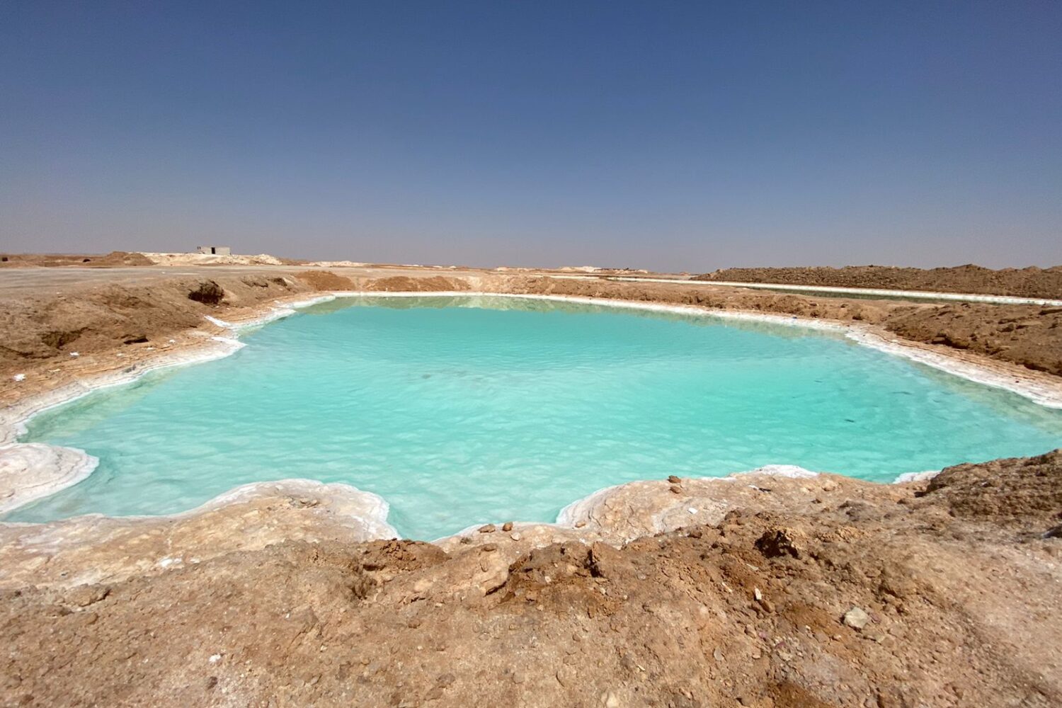Siwa: Los Espejos Brillantes de los Lagos Salados Los lagos salados de tonos turquesa del Oasis de Siwa, con depósitos de sal cristalina en sus orillas, bajo el sol del desierto