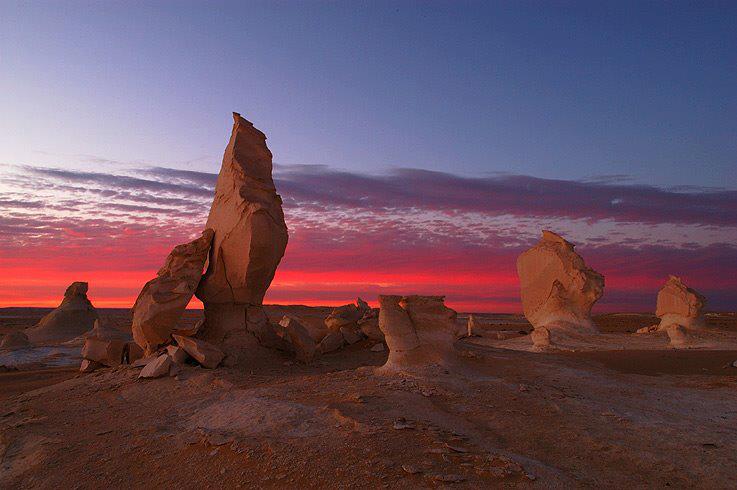 Bahariya’s Desert Symphony: Colors of Sunset A dramatic sunset over Bahariya Oasis, showcasing the rich colors of the desert sky and the silhouette of the oasis landscape