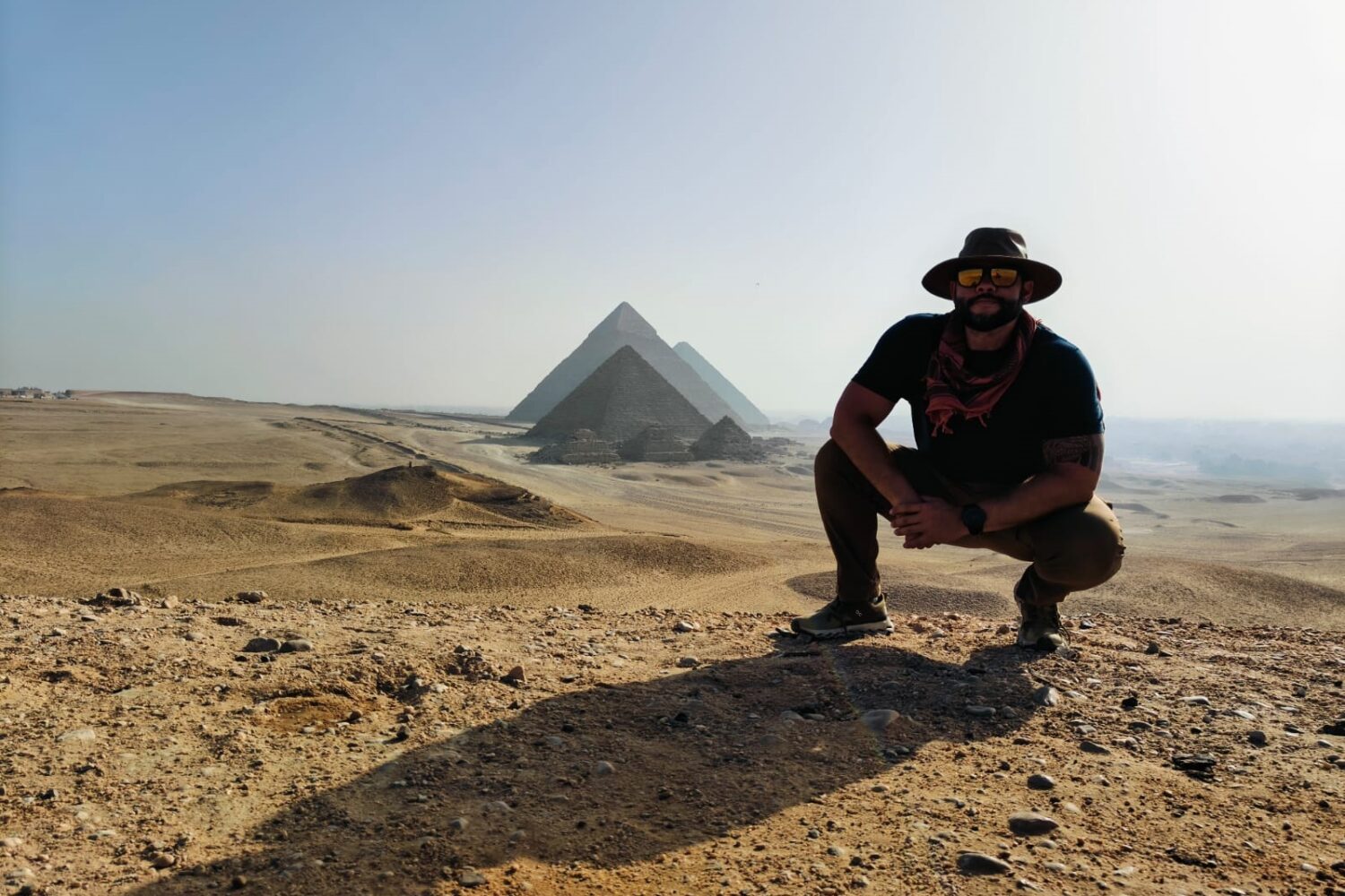 Vue panoramique du plateau des pyramides de Gizeh en Égypte, montrant les trois grandes pyramides de Khéops, Khéphren et Mykérinos s'élevant du désert