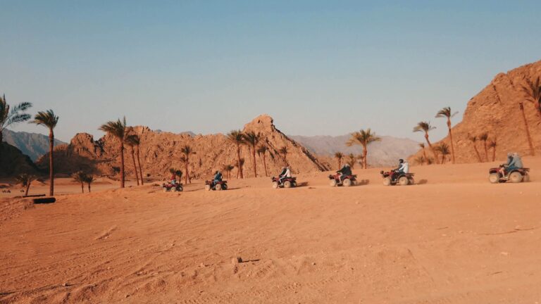 A group of people on quad bikes navigating a desert trail near Hurghada