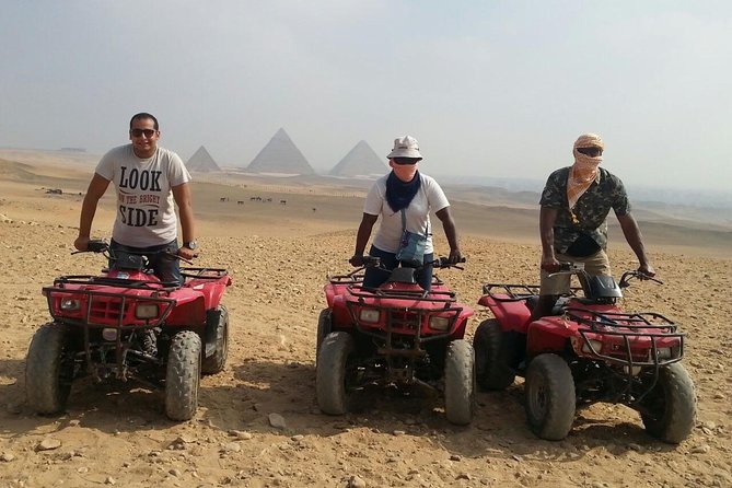 A quad bike traversing the sandy Giza Plateau, with the pyramids in the distance