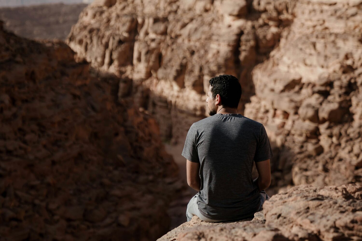 sitting peacefully on a mountain slope in Sinai, enjoying the tranquility of the desert landscape