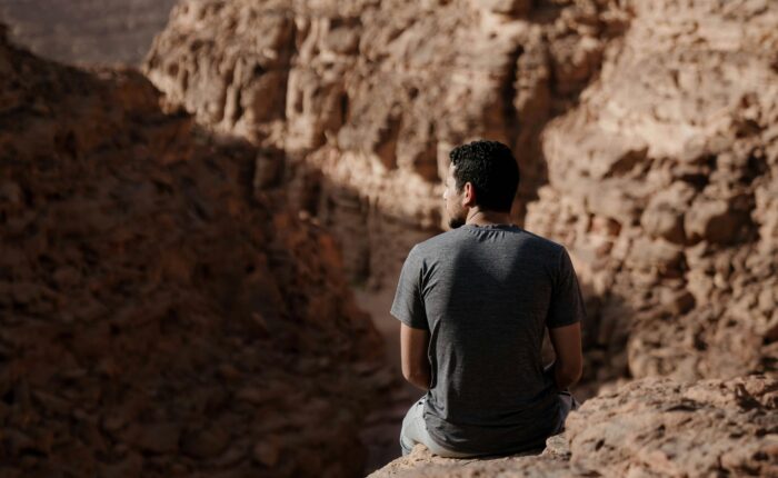 sitting peacefully on a mountain slope in Sinai, enjoying the tranquility of the desert landscape